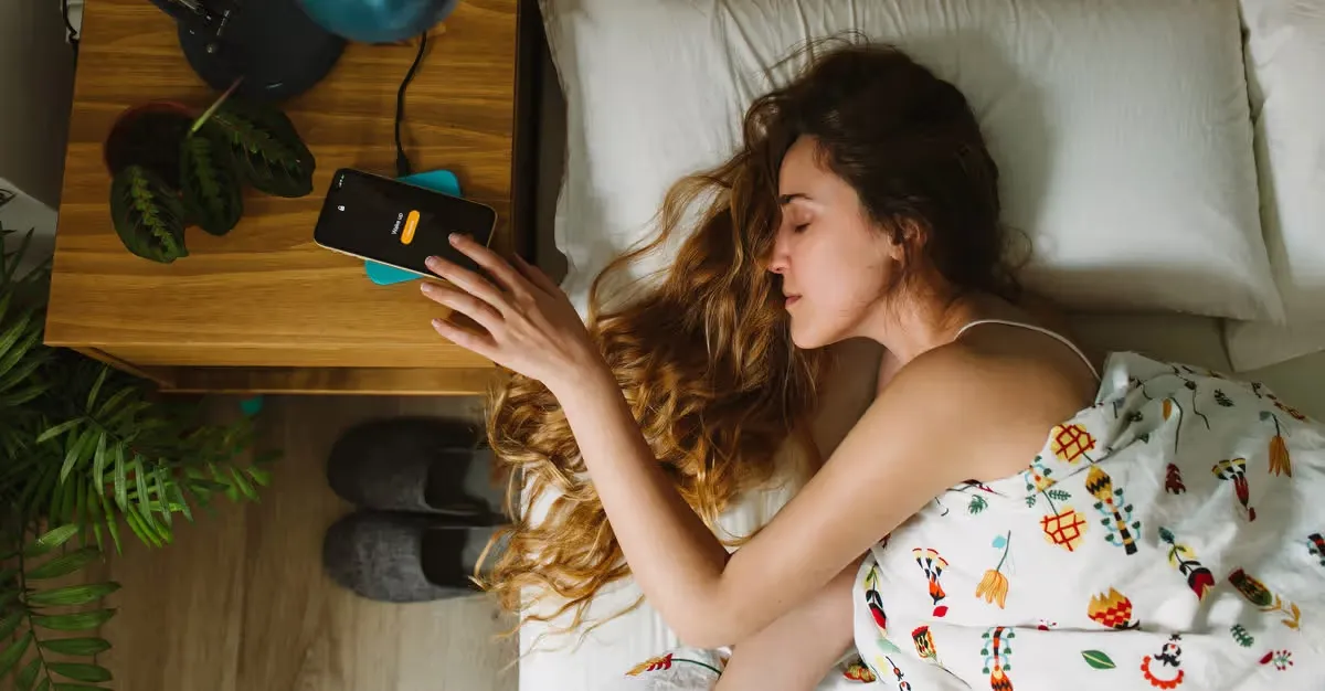 دست زن روی موبایل در تخت خواب